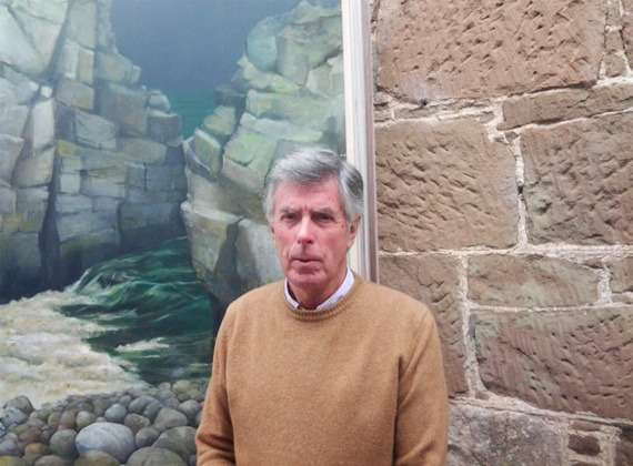 Painting teacher Ian Hamilton. Painting teacher Ian Hamilton in front of a landscape painting.