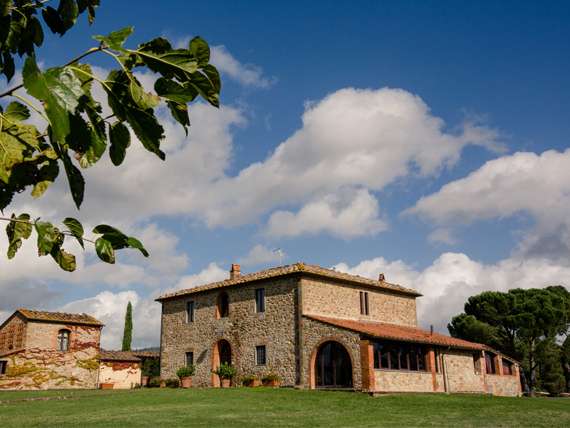 View of rustic Tuscan villa surrounded by cypress trees. View of rustic Tuscan villa surrounded by cypress trees.